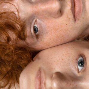 Faces. Fashion portrait of beautiful redhead couple isolated on grey studio background. Concept of male beauty, skin care, fashion and style. Artwork, modern and trendy portrait. Attractive models.