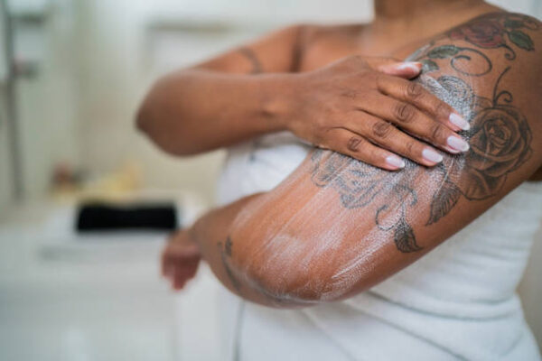 Woman applying body mosture GRASSFIELD by Ruth in the bathroom at home